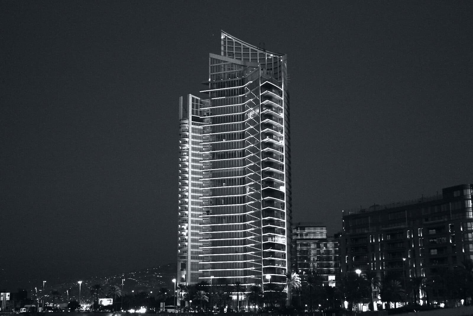 A corporate tower at night, floor lines picked out in light