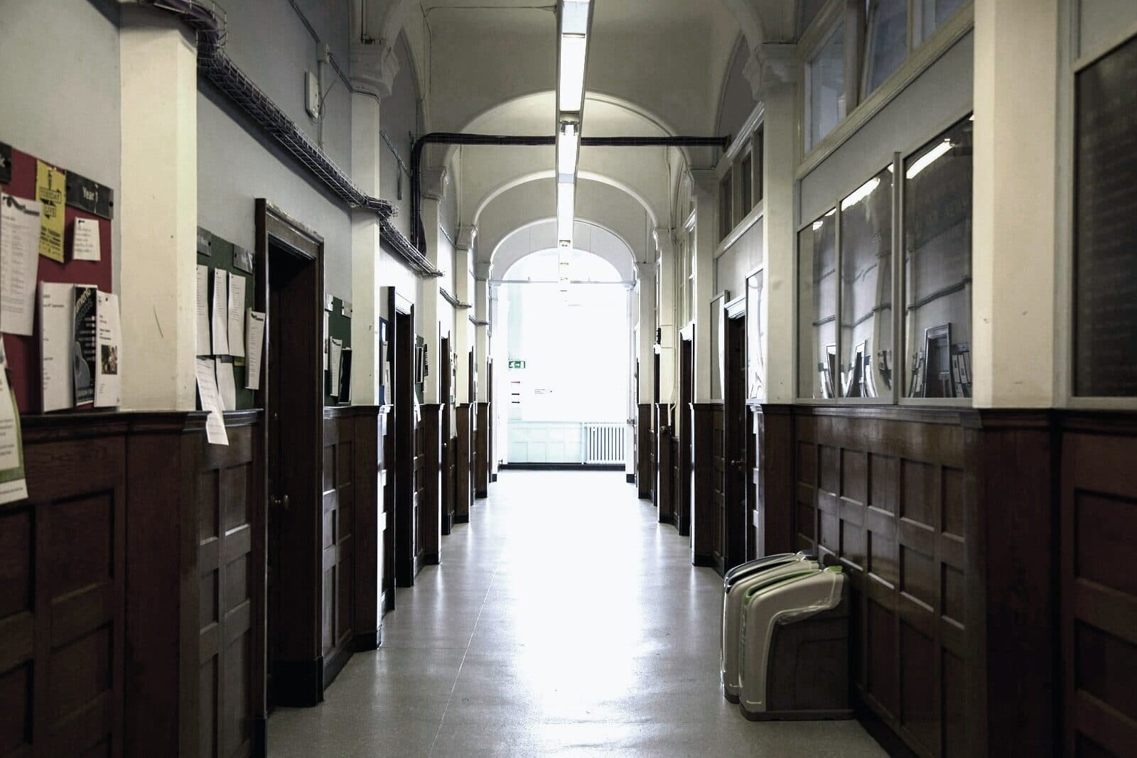 An empty school corridor lined with doors and lockers